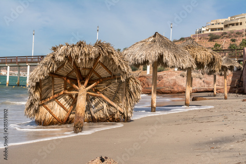 Bilde på lerret La brisa tumbó la palapa de la playa.