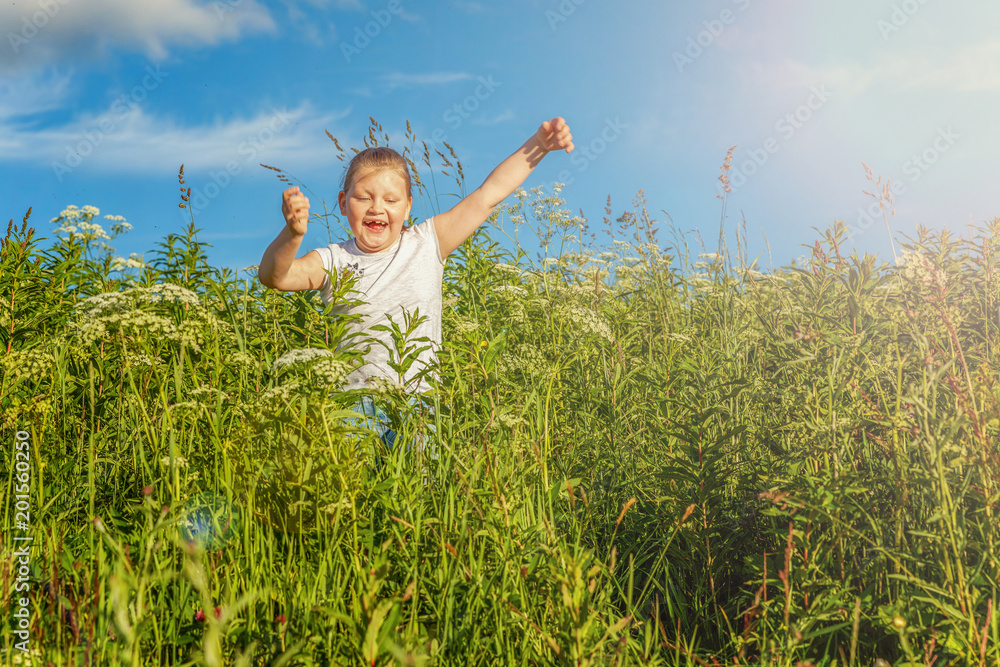 Happy cute little girl running on the grass in the park. Happiness. Healthy preschool children summer activity. Kids playing outdoors Happy cute little girl running on the grass in the park. Happiness. Healthy preschool children summer activity. Kids playing outdoors