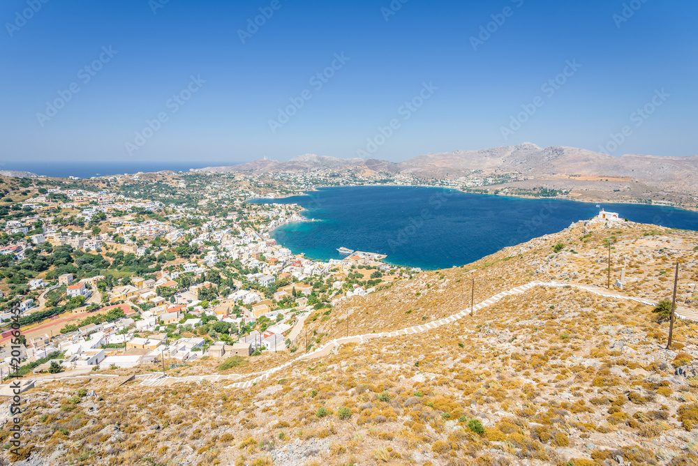 Beautiful sunny greek white church and village town Agia Marina harbor view to the greek blue sea water from the old castle surrounded mountains, Medieval Castle, Leros, Dodecanese Islands, Greece 
