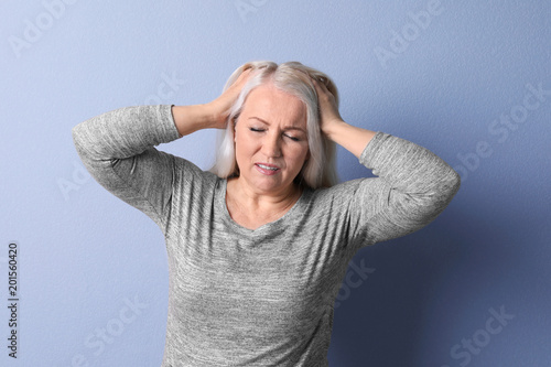 Φωτογραφία Mature woman suffering from headache on color background