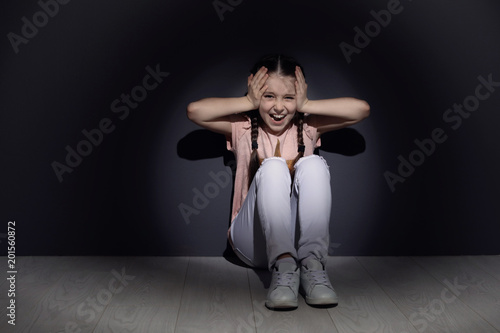 Depressed little girl sitting on floor indoors. Time to visit child psychologist