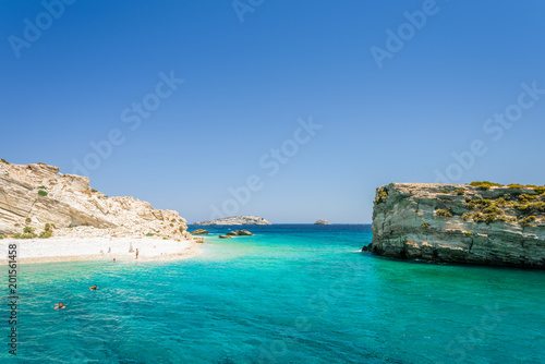 Beautiful sunny coast view to a small greek island and crystal clear blue water beach with some boats cruising and people swimming, White Island, Aspronisi, Leros, Dodecanese/ Greece – July 22 2017