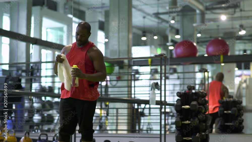 Young man taking a break in a gym Young man taking a break in a gym