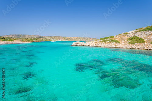 Beautiful sunny coast view to a small greek island bays and crystal clear blue water beach like paradise with some boats cruising or fishing, Arki, Tiganakia Beach, Leros, Dodecanese/ Greece 