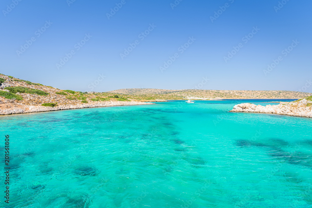 Beautiful sunny coast view to a small greek island bays and crystal clear blue water beach like paradise with some boats cruising or fishing, Arki, Tiganakia Beach, Leros, Dodecanese/ Greece 
