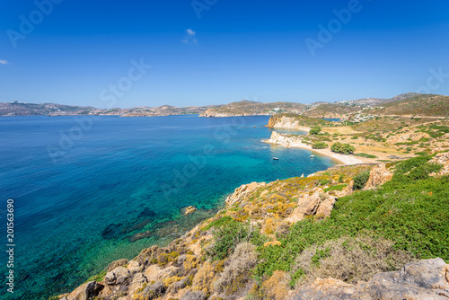 Fototapeta Naklejka Na Ścianę i Meble -  Amazing sunny coast view to a empty holiday bay Didymes beach with crystal clear blue water sandy beach for sunbathing and some boats cruising fishing in background, Patmos Island, Dodecanese, Greece