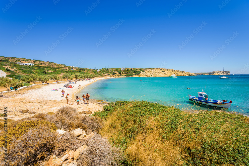 Pretty sunny coast view to a cozy holiday bay with crystal clear blue water sandy beach for sunbathing and some boats cruising fishing, Lipsi Island, Patmos, Dodecanese, Greece
