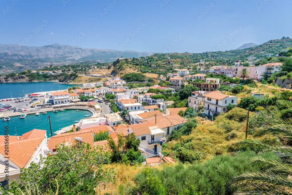 Beautiful sunny greek village town white house and harbor view to the aegean blue sea with crystal clear water and fishing boats cruising yacht white houses, Ikaria Island, Evdilos, Sporade, Greece