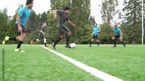 Male soccer players playing soccer game.