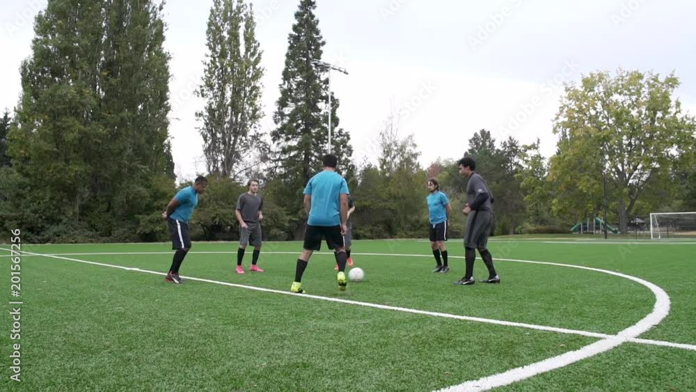 Male soccer players standing in circle passing ball. Male soccer players standing in circle passing ball.