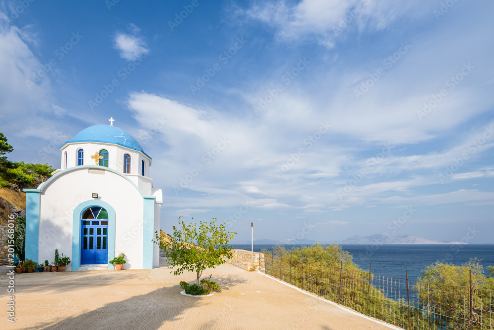 Beautiful blue white greek church basilica chapel in the middle of a small greek mountain village with views to mediterranean sea on the island of Ikaria, Agios Kirykos, Sporades, Greece