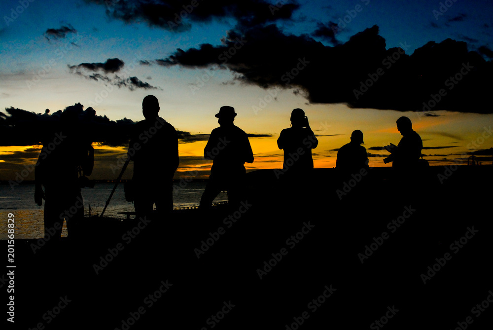 Fotógrafos fazendo fotos do pôr do sol na beira do rio negro no amazonas