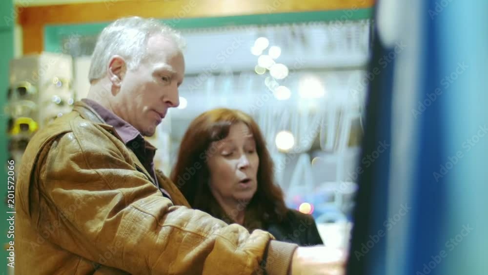 Elderly loving couple shopping for some clothes at a store Elderly loving couple shopping for some clothes at a store