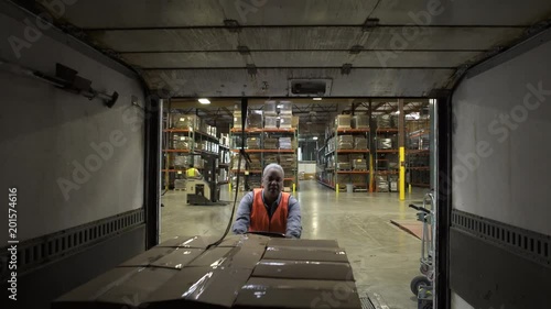 Mid adult woman pushing out boxes from a warehouse