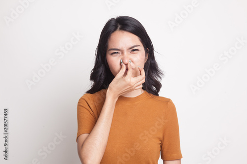 Young Asian woman  holding her nose because of a bad smell.