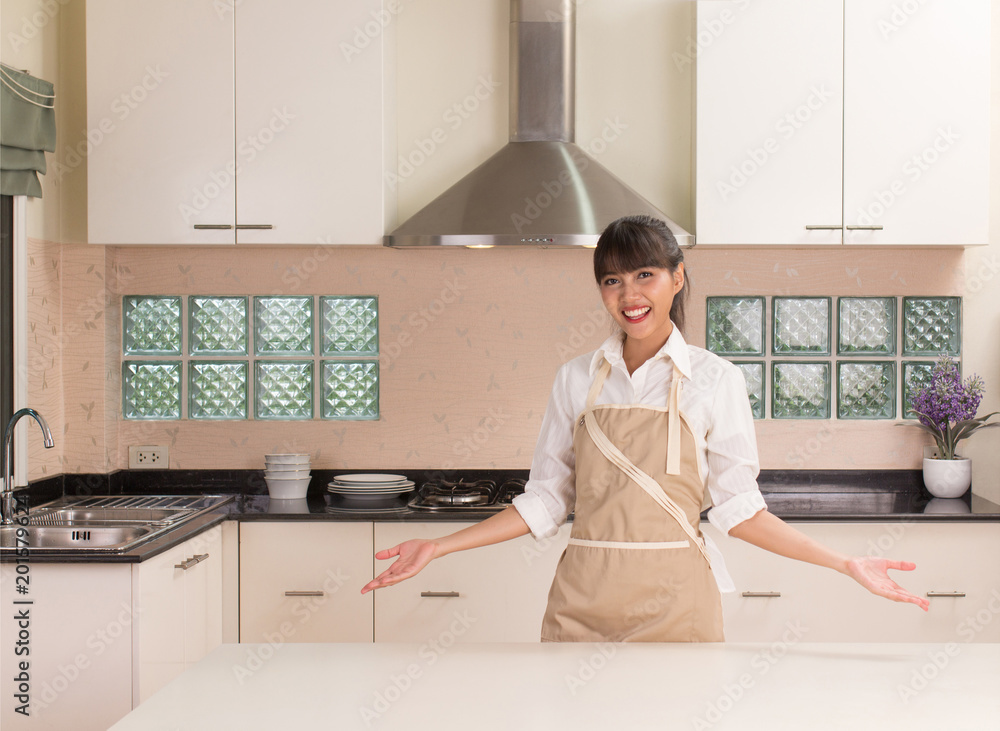 Young beautiful girl smiling in front of the modern style kitchen Young beautiful girl smiling in front of the modern style kitchen