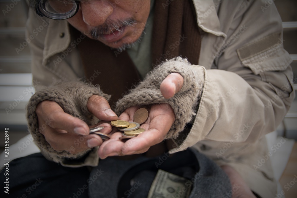 Homeless senior adult man sitting and begging in overpass