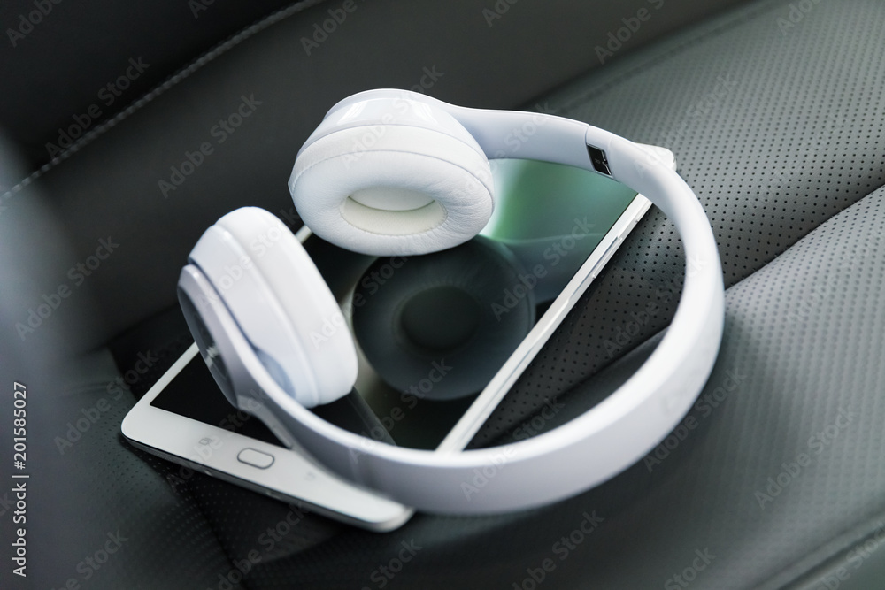 Headphones and tablet computer on the car seat Headphones and tablet computer on the car seat