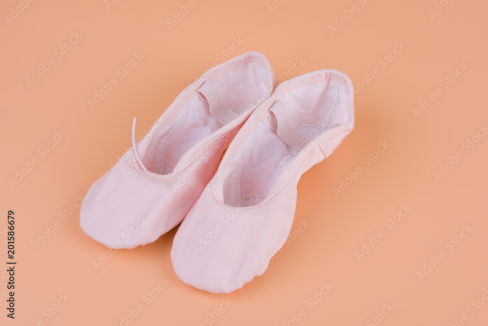 Small ballet shoes on yellow background Small ballet shoes on yellow background