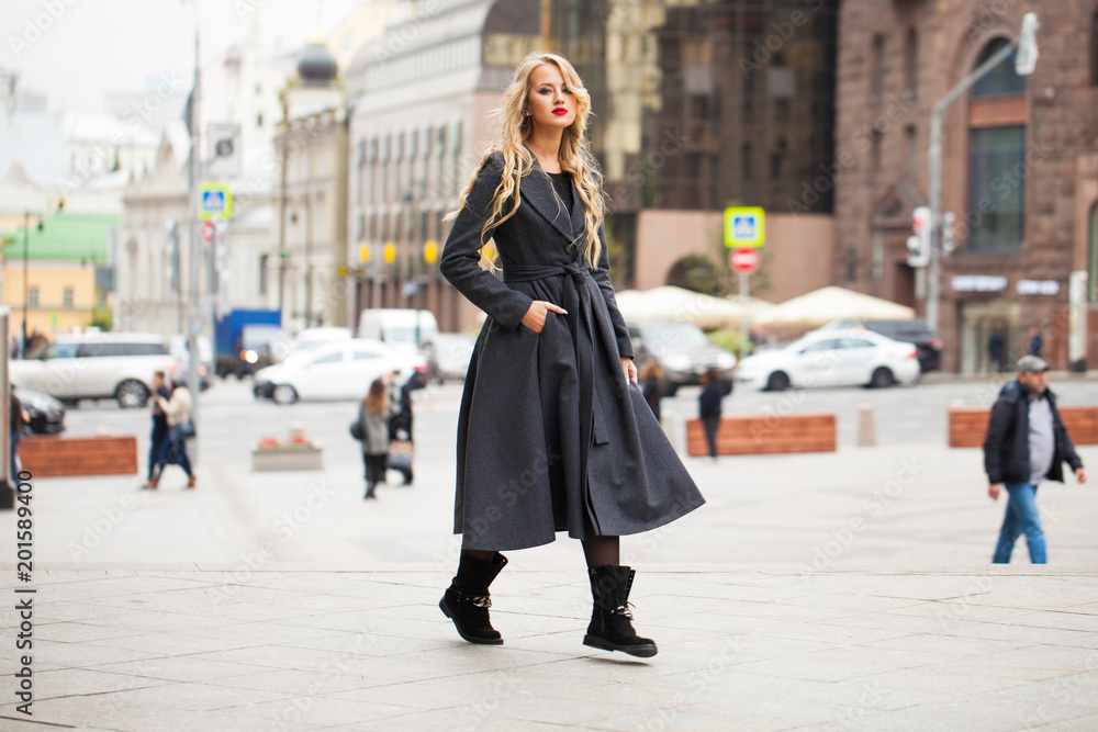 Fototapeta premium Portrait of a young beautiful woman in gray coat