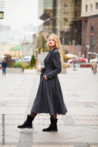 Portrait of a young beautiful woman in gray coat © Andrey_Arkusha