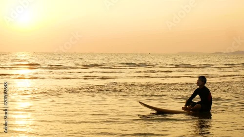 Wallpaper Mural 4K. silhouette of surfer man relax by sitting on surfboard over the sea at sunset on tropical beach. sport and recreation for summer season concept Torontodigital.ca