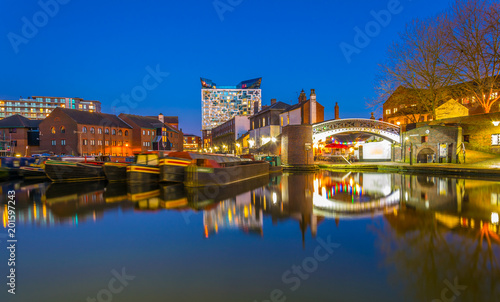 The cube behind brick buildings alongside a water channel in the central Birmingham, England