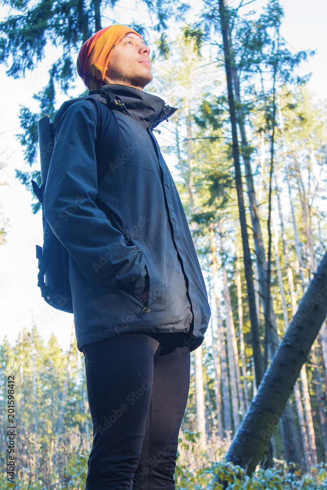 Traveler with a backpack hiking in the pine forest Traveler with a backpack hiking in the pine forest
