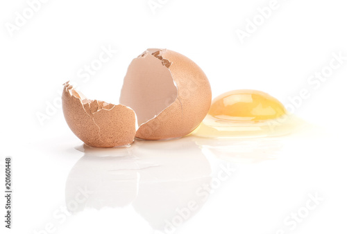One cracked brown chicken egg isolated on white background raw yolk was separated from the broken eggshell.