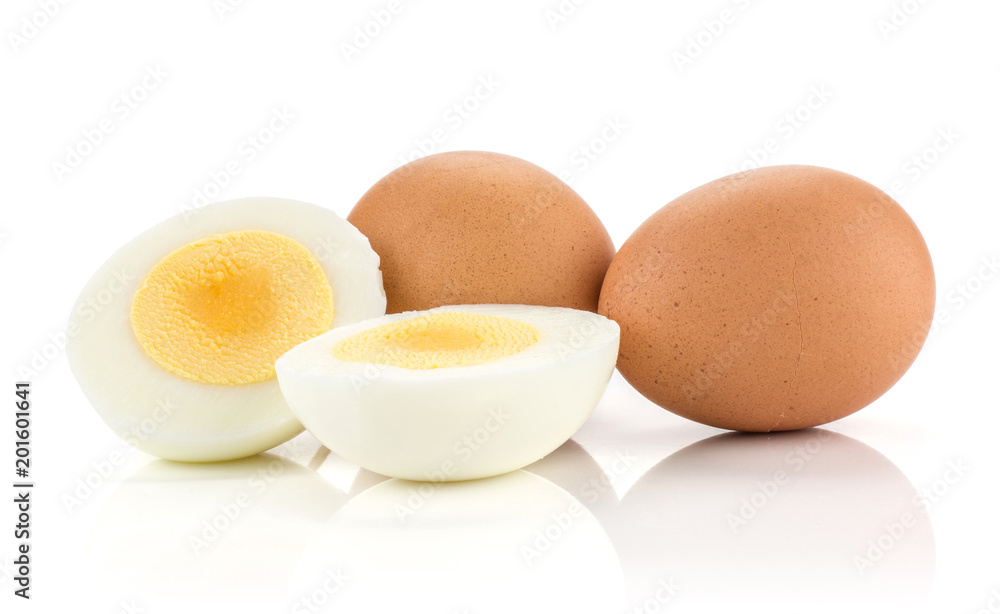 Two brown chicken eggs with boiled sliced halves isolated on white background.