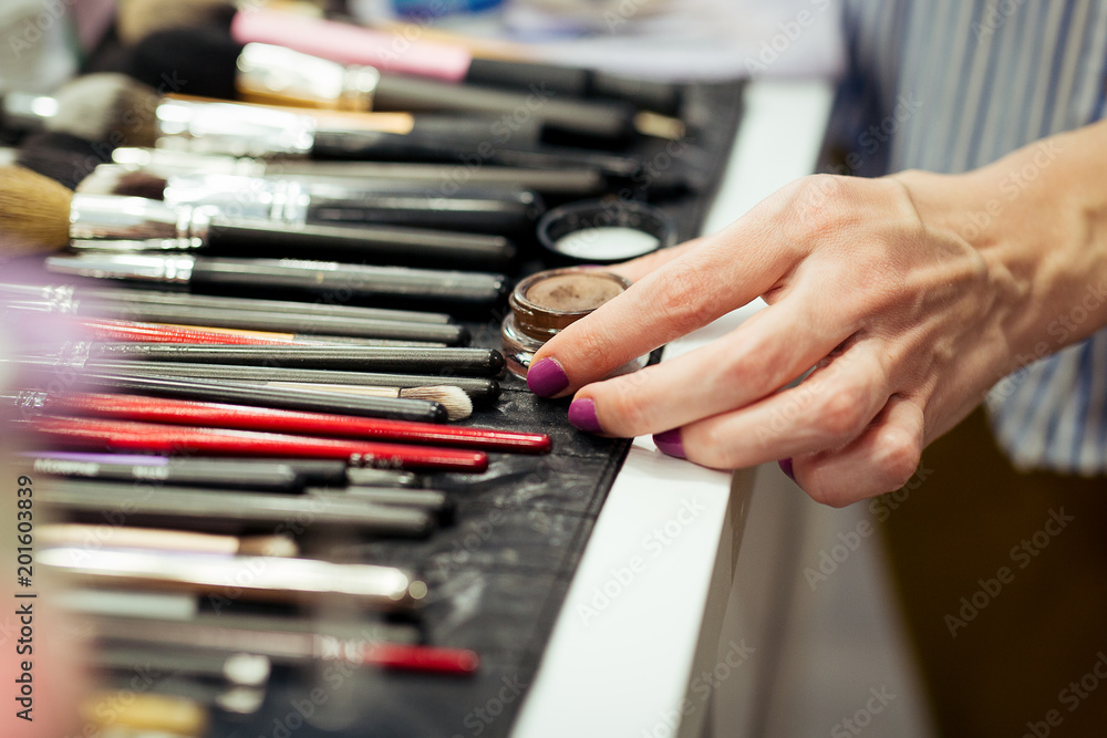 Female makeup artist with cosmetics at work close-up Female makeup artist with cosmetics at work close-up