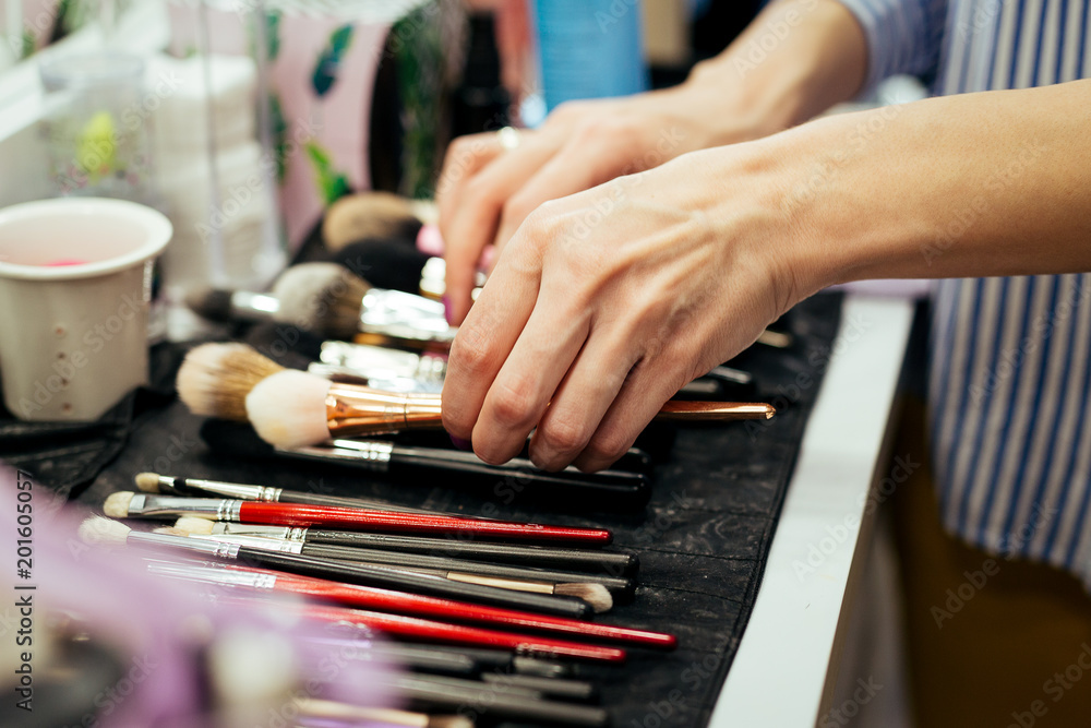 Female makeup artist with cosmetics at work close-up Female makeup artist with cosmetics at work close-up