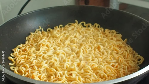 cooking, instant noodles boiling in hot water in frying pan.