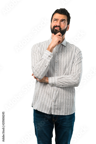 Handsome man with beard standing and thinking an idea photo