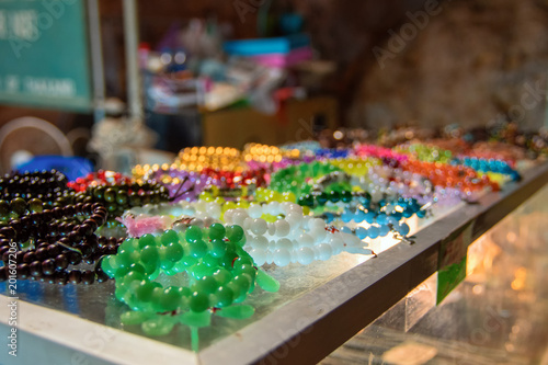 Souvenir glass beads of different colors lie on the counter. Concept of street trading the trinkets, cheap fakes.