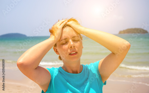 Woman on hot beach with sunstroke. Health problem on holiday. Medicine on vacation.