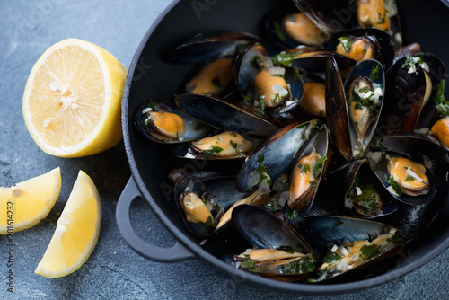 Closeup of freshly cooked mussels in a cast-iron pan, selective focus, horizontal shot