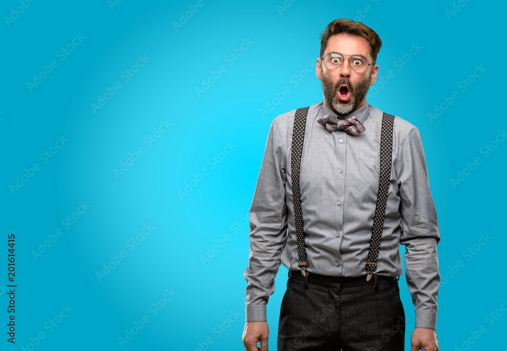 Middle age man, with beard and bow tie happy and surprised cheering expressing wow gesture Middle age man, with beard and bow tie happy and surprised cheering expressing wow gesture