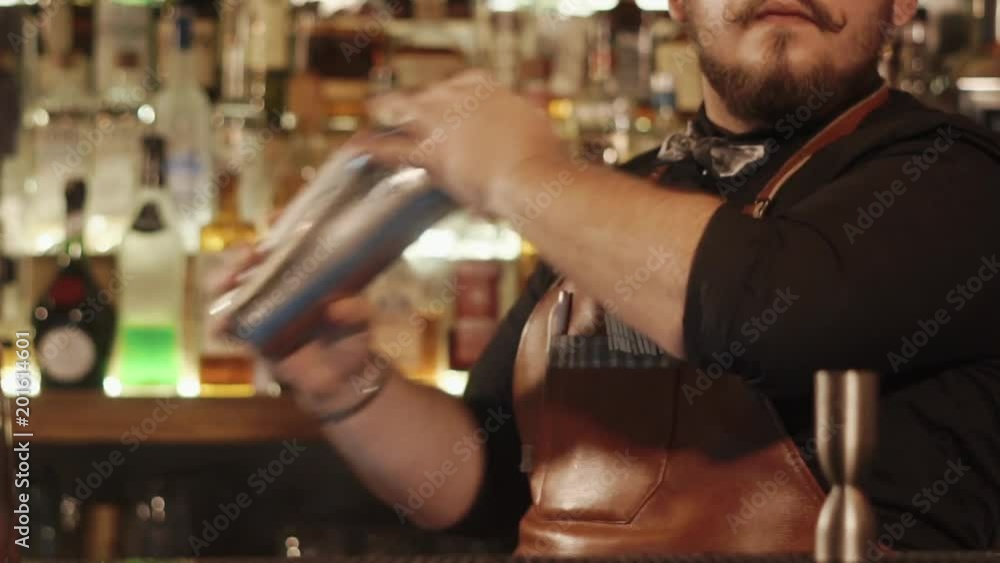 close up shot of the barman's hands, a man makes a non-alcoholic cocktail, he mixes the ingredients in a metal shaker, then leaves everything in a glass close up shot of the barman's hands, a man makes a non-alcoholic cocktail, he mixes the ingredients in a metal shaker, then leaves everything in a glass