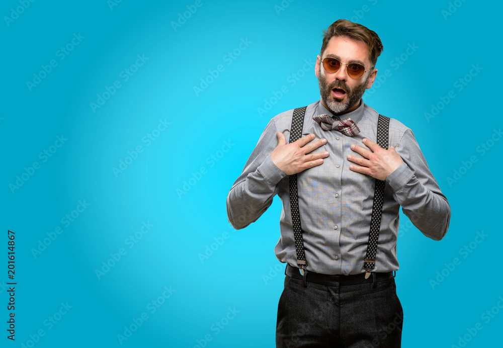 Middle age man, with beard and bow tie happy and surprised cheering expressing wow gesture Middle age man, with beard and bow tie happy and surprised cheering expressing wow gesture