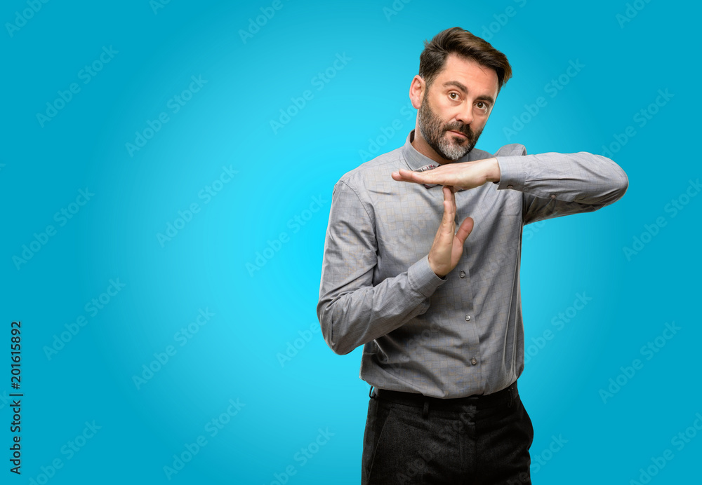 Middle age man, with beard and bow tie serious making a time out gesture with hands Middle age man, with beard and bow tie serious making a time out gesture with hands