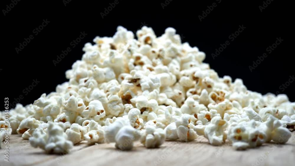 Fluffy popcorn macro, airy popped corn snack served at cinema, entertainment. On a rotating wooden table. 4K Fluffy popcorn macro, airy popped corn snack served at cinema, entertainment. On a rotating wooden table. 4K