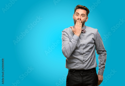 Middle age man, with beard and bow tie covers mouth in shock, looks shy, expressing silence and mistake concepts, scared