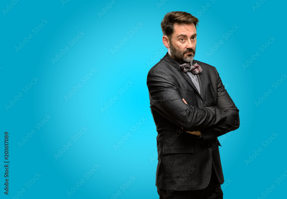 Middle age man, with beard and bow tie with crossed arms confident and happy with a big natural smile laughing Middle age man, with beard and bow tie with crossed arms confident and happy with a big natural smile laughing