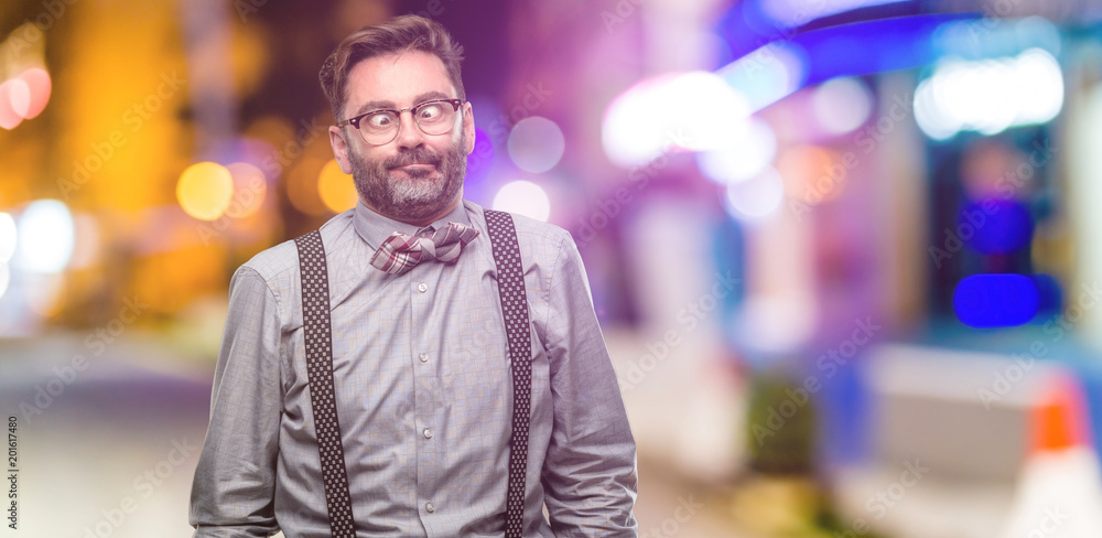 Middle age man, with beard and bow tie making funny face fooling at night club