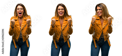 Beautiful young woman happy and excited expressing winning gesture. Successful and celebrating victory, triumphant over white background