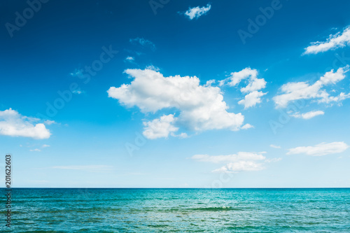 Blue sea and blue sky with clouds. © smallredgirl