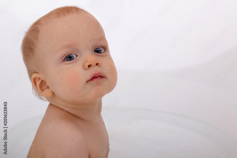 Cute baby boy against white background. Funny infant in bath tube looking t camera. Copy space Cute baby boy against white background. Funny infant in bath tube looking t camera. Copy space