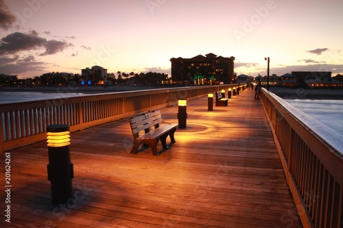 Deerfield Beach, Florida Pier Boardwalk After Dusk with Lights Illuminated, Park Sitting Benches, Atlantic Ocean on Either Side and Hotels in the Distance photo