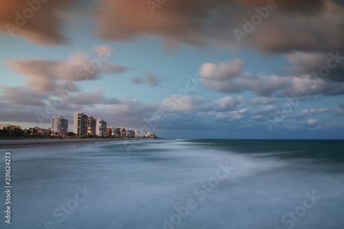 Facing North from Deerfield Beach Pier the Foam and Froth of the Waves of the Atlantic Ocean Blurred in a Long Time Exposure with Condos in the Background After Dusk © kthx1138